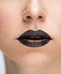 Fototapeta premium Lips painted with black lipstick