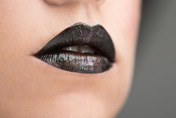 Fototapeta premium Lips painted with black lipstick