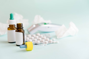 flu treatments. Spray for the nose or a pill to treat colds and gripes. Glass Bottle with medicines and paper handkerchiefs on blue background. Copy space for text. mockup, Top view. flat lay.