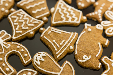 Decorated candy gingerbread with sugar topping white on plate.