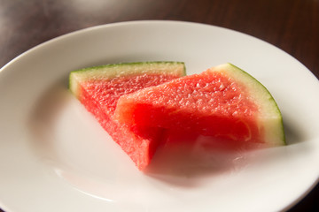Slice of delicious watermelon on white plate background