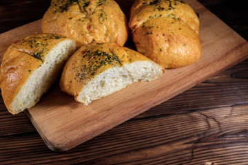 Fresh bread ciabatta on cutting board on wooden table