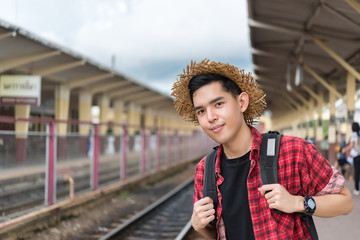 Asian tourist wait train at train station,thailand hipster man go to travel