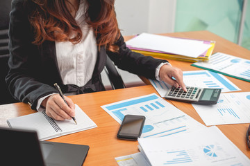 Business woman at working with financial reports and laptop computer in the office