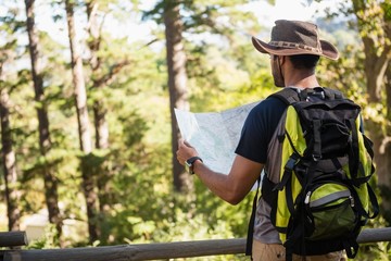 Man reading the map near the wooden fence