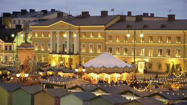 Traditional holiday market with Christmas Tree, decorations and children's rides on Senate Square opposite the Cathedral Helsinki, Finland