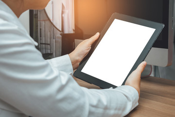 Close up hands holding tablet with blank white screen on her desk