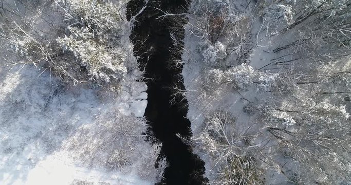 60fps Aerial view of flowing water in a Maine stream just after a snow storm covered the landscape in a blanket of white. Taken 12-10-2017
