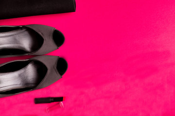 Fashion Lady Accessories Set. Black and pink. Minimal. Black Shoes, lipstick and bag on pink background. Flat lay.