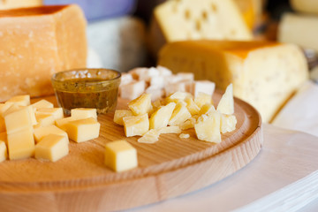 Cheese platter, parmesan on natural wood plate with sauce