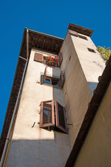 Fototapeta na wymiar Beautiful tower building with windows in wooden roller shutters in Florence, Italy