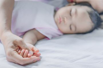 Asian baby and mother sleeping on the bed,thailand people,relax time,selective focus