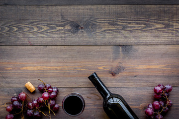 Drink wine concept. Bottle, glass, grape on wooden background top view copyspace