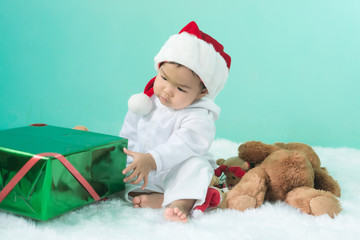 Portrait of asian baby girl wear santa hat with bear doll,Thailand people