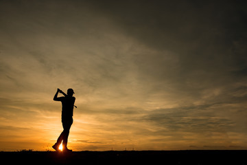 Fototapeta premium silhouette asian golfer playing golf during beautiful sunset