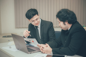 Two asian businessmen discuss about business of company,Two people are talking about work stress and more serious.