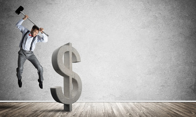 Determined banker man in empty concrete room breaking dollar figure