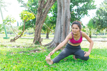 Asian slim woman warm up before work out in a morning,slim girl exercise for life,selective focus,fill bright sunlight,Thailand people