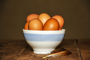 Easter bowl with Easter eggs on a wooden background.