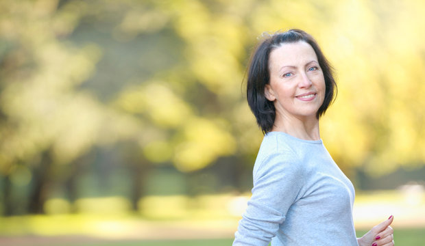 Portrait of mature woman weared in sports clothes in the park