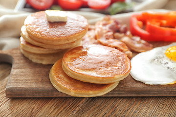 Obraz na płótnie Canvas Board with yummy pancakes on wooden table