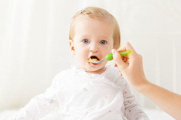 Little baby feeding with a spoon