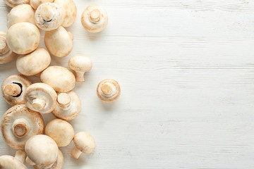 Fototapeta na wymiar Fresh champignon mushrooms on wooden background