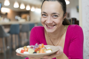 Business woman eating salad on lunch break in City Park living healthy lifestyle. Happy smiling multiracial young businesswoman