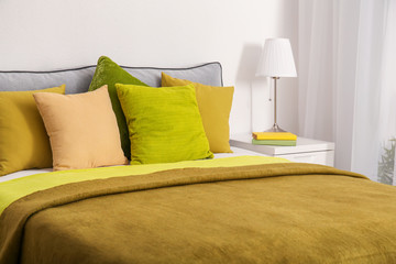 Comfortable bed with cushions in room