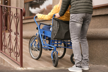 Man and his wife in wheelchair on ramp outdoors