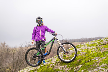 Obraz premium Cyclist holding a mountain bike on top of the free space.