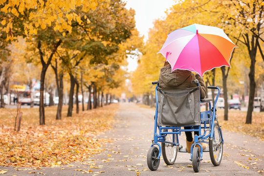 Teenage girl in wheelchair outdoors on autumn day