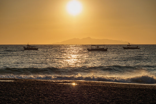 three boats on the sea surface at sunrise