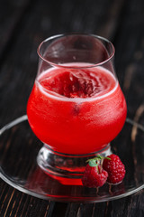 Raspberry cocktail on the dark wood background