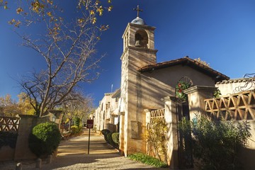 Pedestrian Walkway and Cathedral Bell Tower in Spanish Arts and Crafts Village in Sedona under warm late Autumn Sunshine