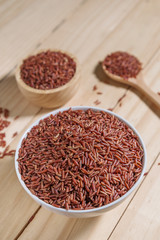 Rice berry in wooden bowl on wood background