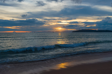 Obraz premium sea waves roll on a sandy beach in the evening during a beautiful sunset
