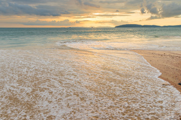 a sea wave on the sandy beach of Ao Nang in Thailand, a beautiful landscape at sunset
