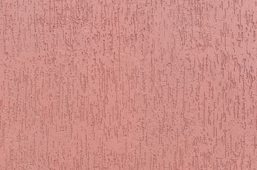 Uniform pink background of plaster with vertical furrows.