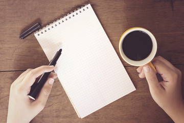 woman hand holding and drinking a arabic coffee and writing