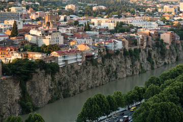 Fototapeta na wymiar Arial view at the banks of an old city of Tbilisi, capital of Georgia, on the river Kura at sunset.
