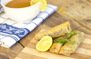 arabic soup in white bowl, and Turkish Pacanga Boregi  and cheddar decorated with slice lemon and leaves mint
