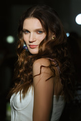 Pretty lady with clean and healthy skin posing in darkness with lights on background