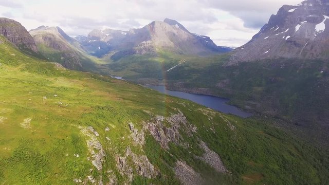 Drone revealing scenic mountain landscape with a rainbow