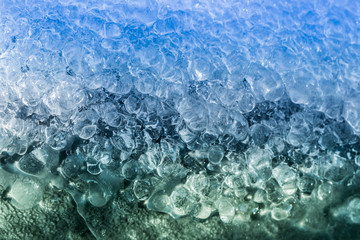 the background of the colored ice. frozen drops of water. tinted green and blue ice