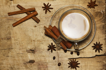 Coffee black with milk, cinnamon, anise on an old board. View from above.