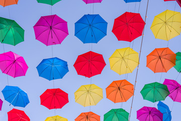 A field of open multi colored umbrellas used as sun protection at a public place somewhere at Torremolinos, Spain (different views)