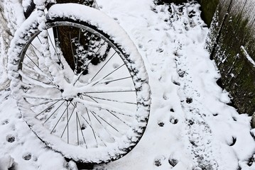 колесо старого велосипеда под белым снегом на улице