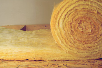 roll of mineral wool lying on the wooden floor