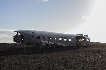 Carcass of airplane on the black beach
